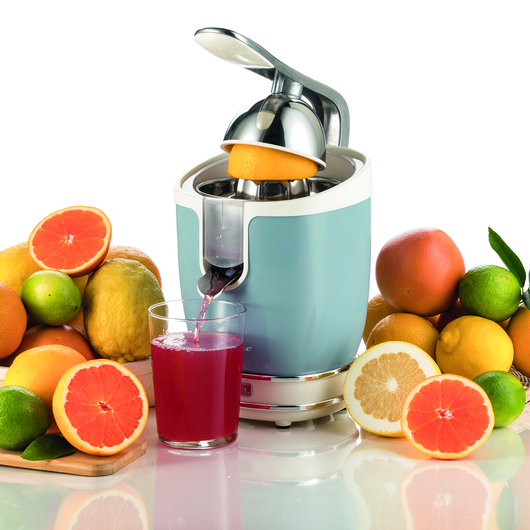Exprimidor con naranjas, limones y pomelos, vertiendo jugo.