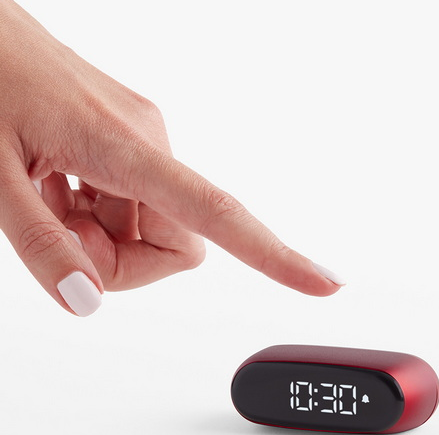 Una mano indica un orologio rosso che mostra le 10:30. Lo sfondo è bianco.