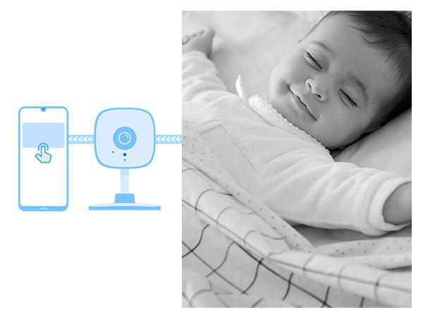 Ein Baby schläft im Bett, während eine Kamera und ein Telefon überwachen.