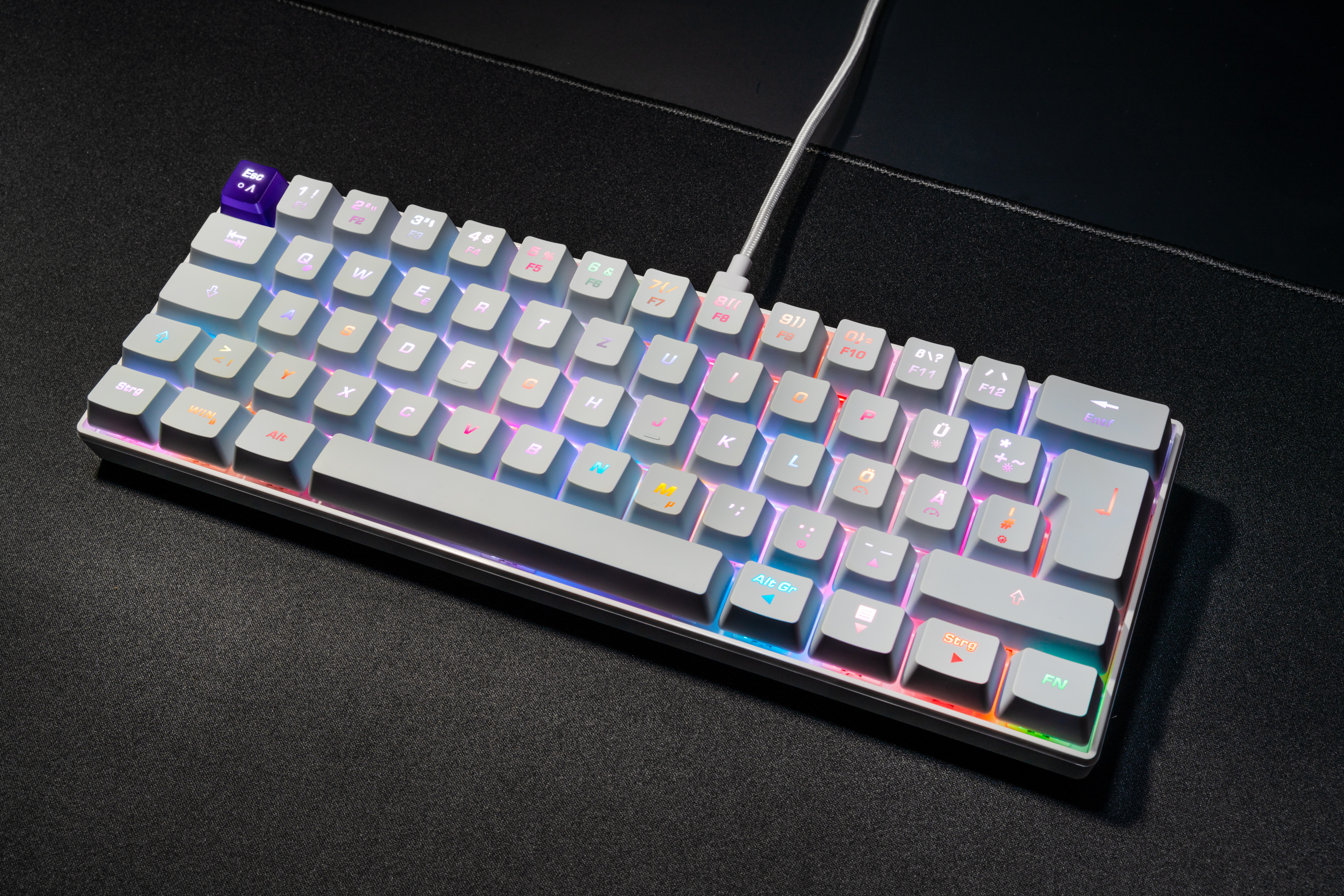 Eine weiße mechanische Tastatur mit farbigen Tasten und Kabel.