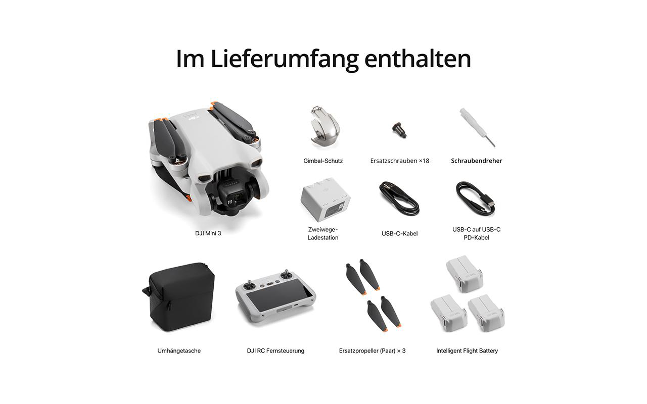 Drohne und Zubehör auf weißer Oberfläche ausgebreitet.