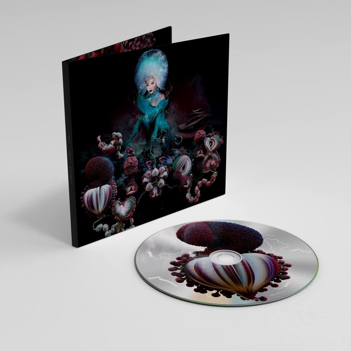 Bjork album borítója és CD-je. Kék hajú nő, virágos és organikus formák között.