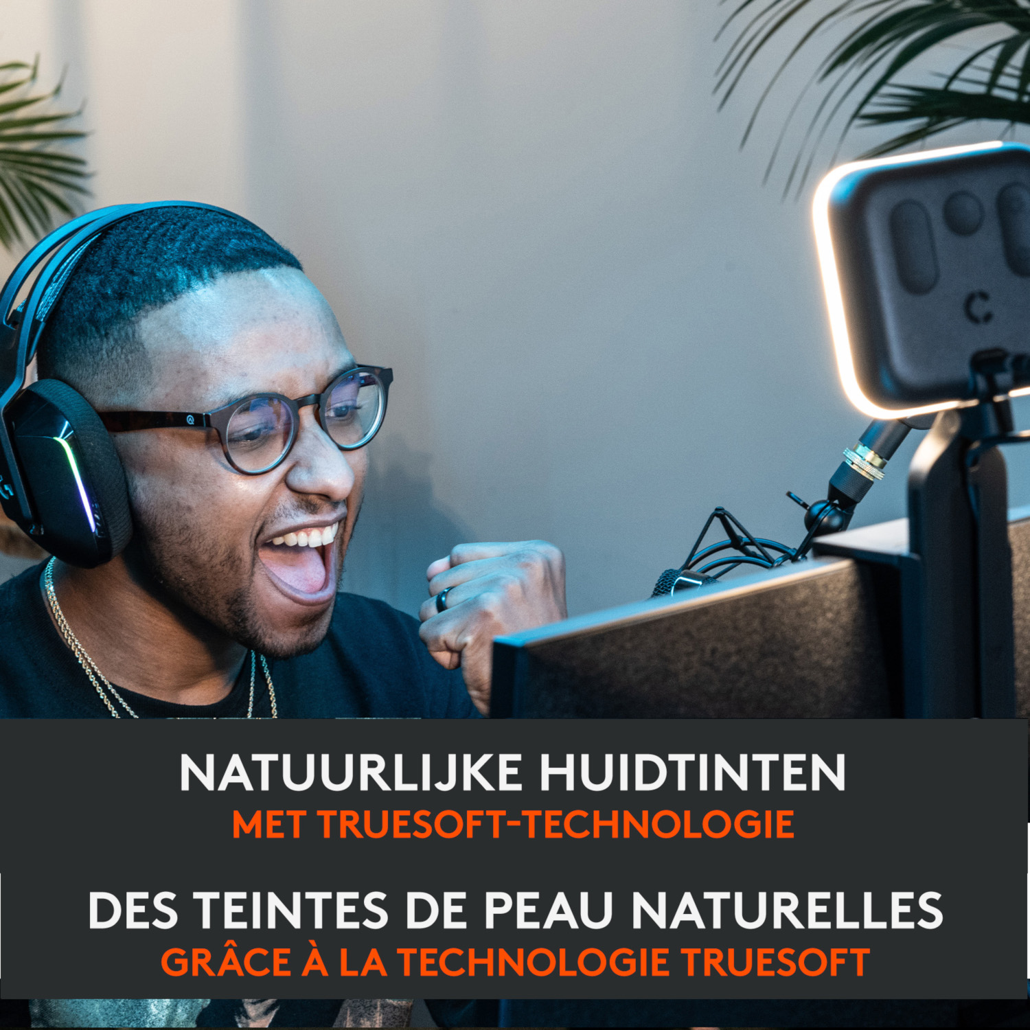 A man wearing headphones and glasses is smiling and cheering with a light in front.