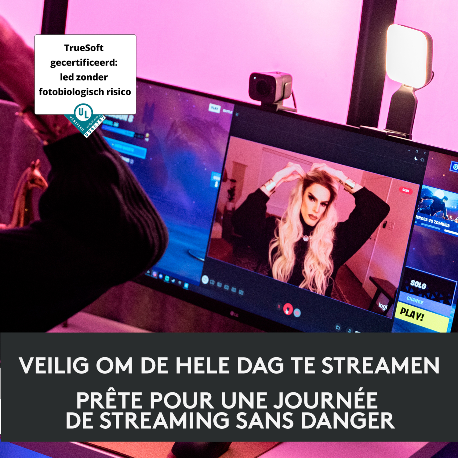 A streamer with a monitor showing gameplay, with a light and webcam.