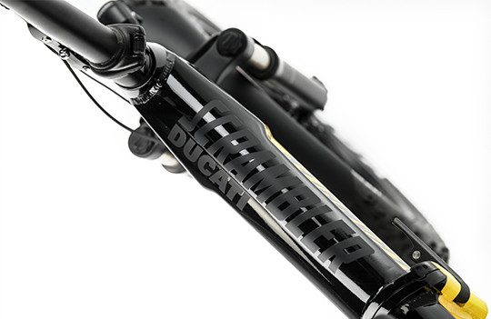 Close-up van een zwart mountainbike frame. De merknaam 'Ducati' is zichtbaar.