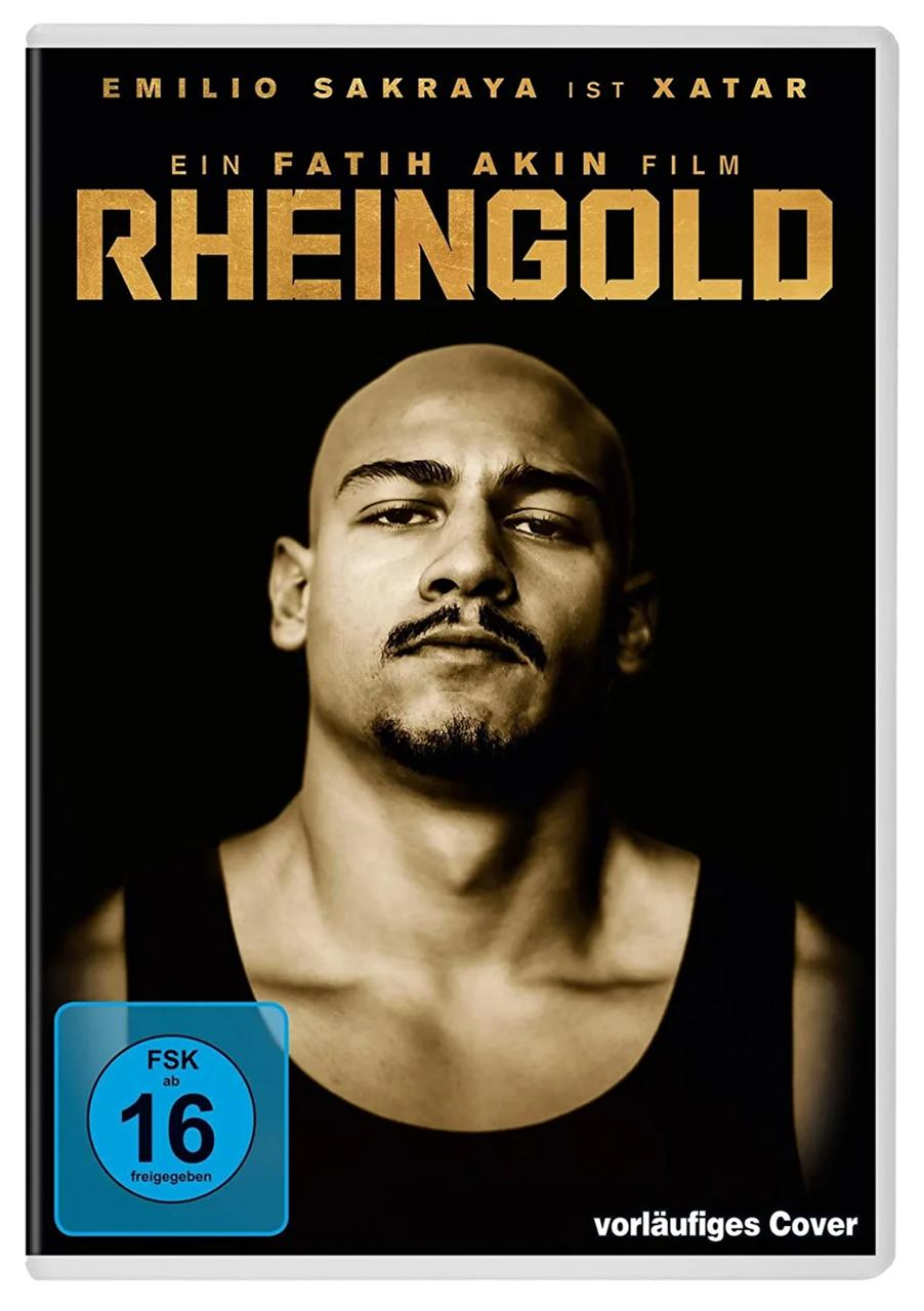 Ein Mann mit Glatze und Schnurrbart trägt ein schwarzes Tanktop. Der Filmtitel ist RHEINGOLD.