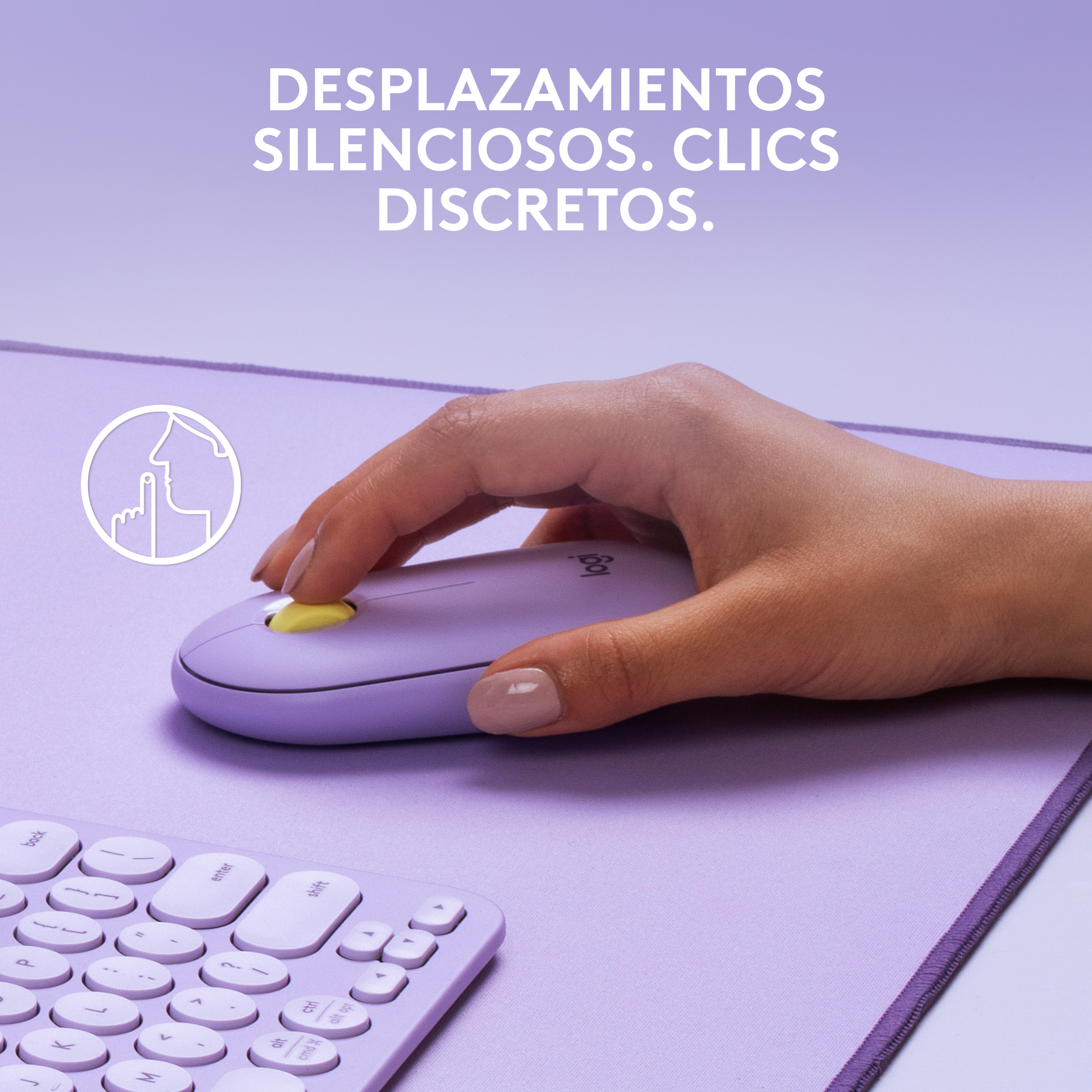 Mano usando un ratón Logitech morado sobre una alfombrilla morada, con teclado.