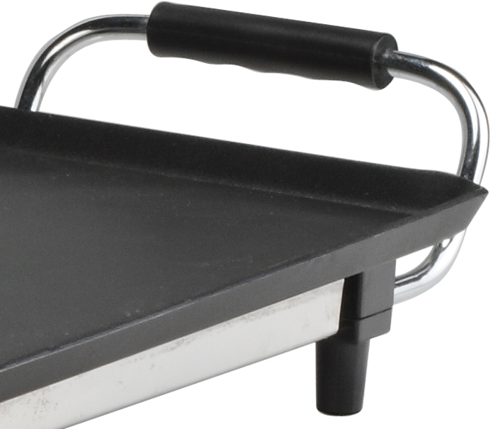 Gros plan d'une plaque de cuisson noire avec une poignée et un cadre argentés, vue d'un angle.