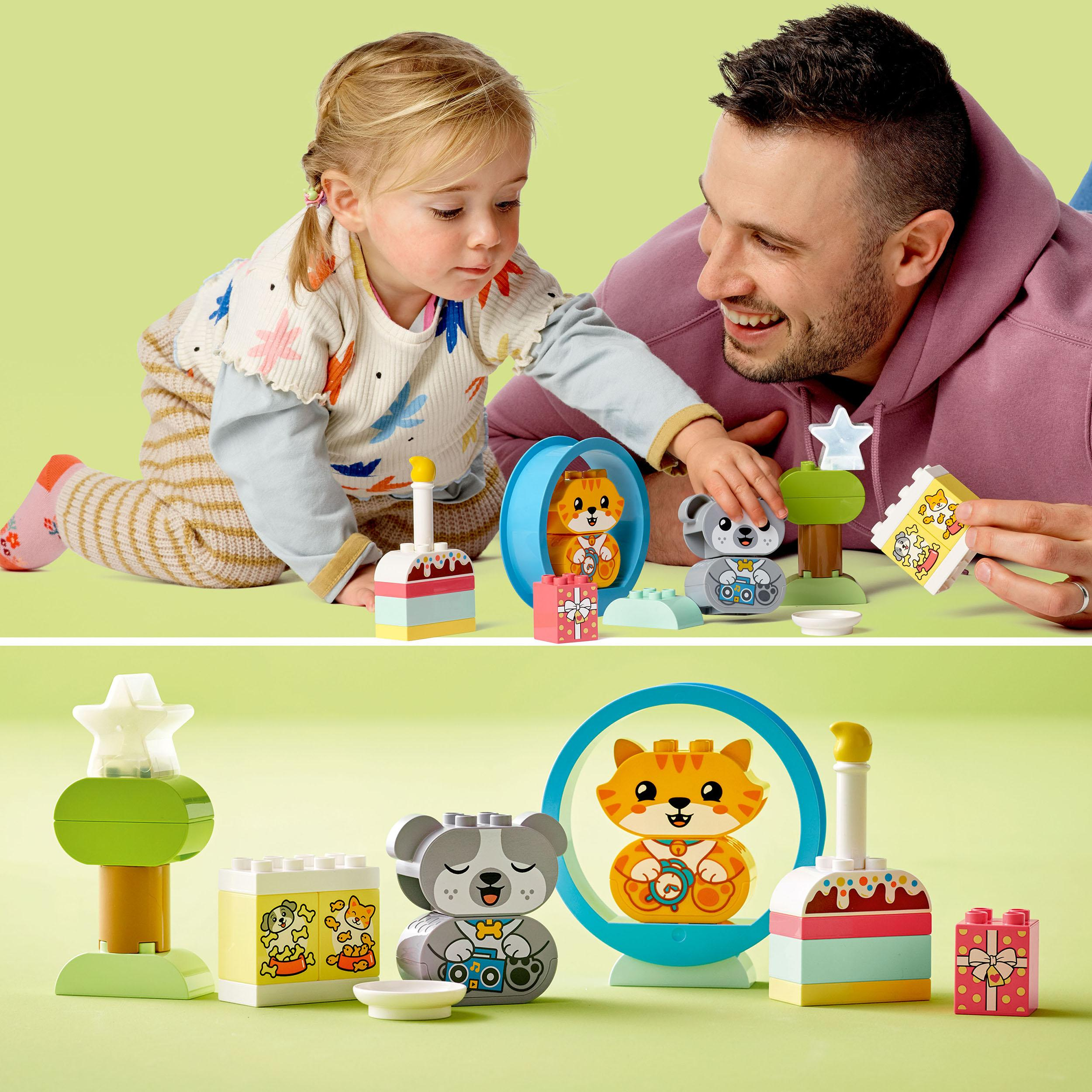 Kind und Erwachsener spielen mit Lego Duplo Bausteinen. Bunte Blöcke auf grüner Oberfläche.