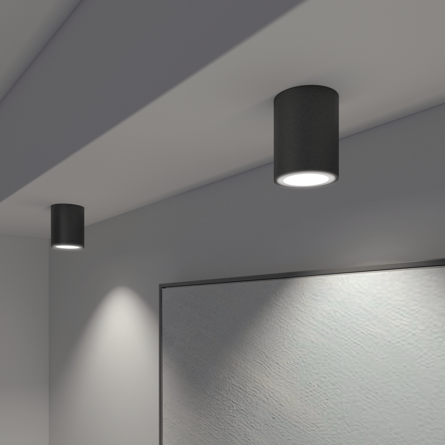 Two black cylindrical lights attached to a white ceiling.  A picture is on the wall.