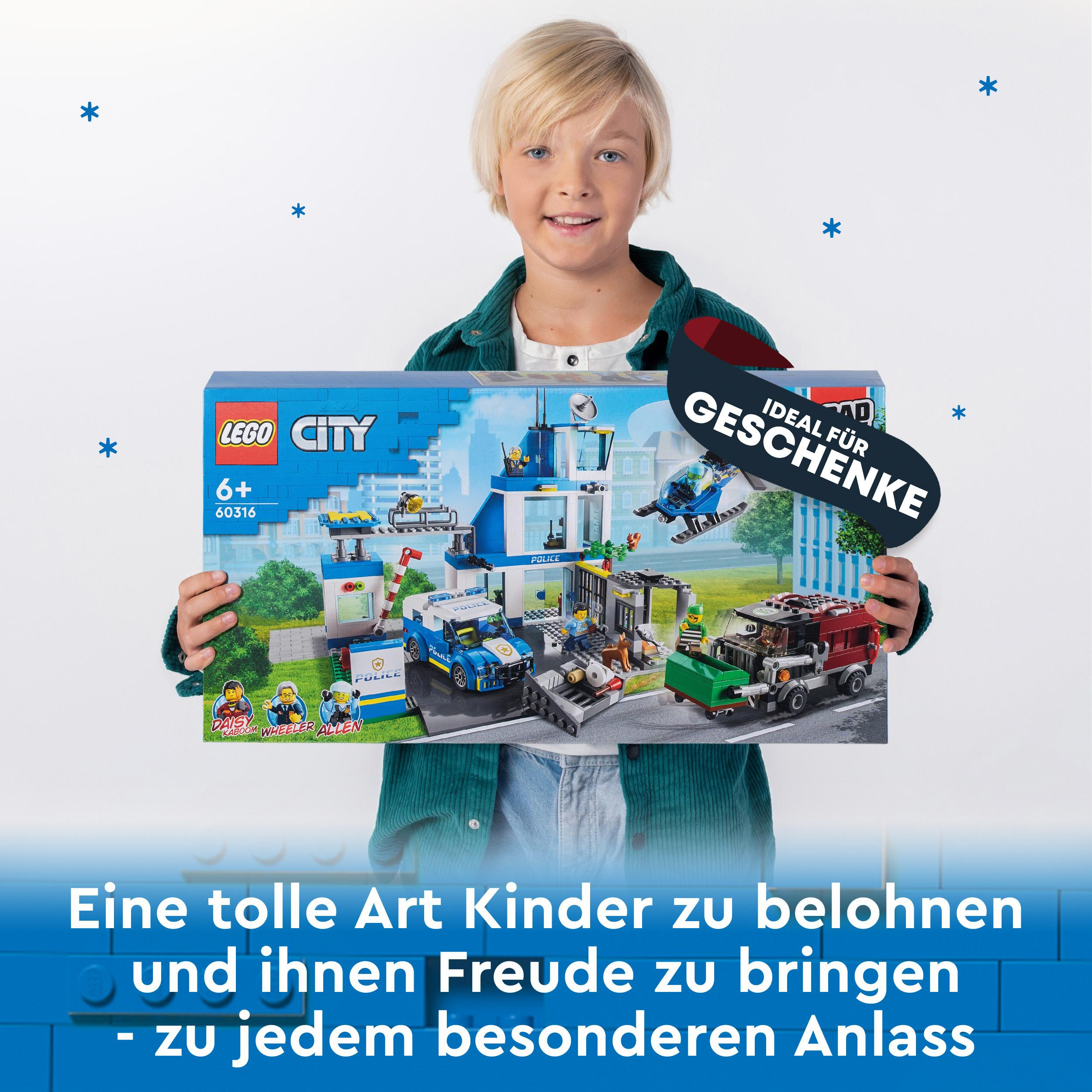 Ein Junge hält eine Lego City Box mit einer Polizeistation und Figuren.