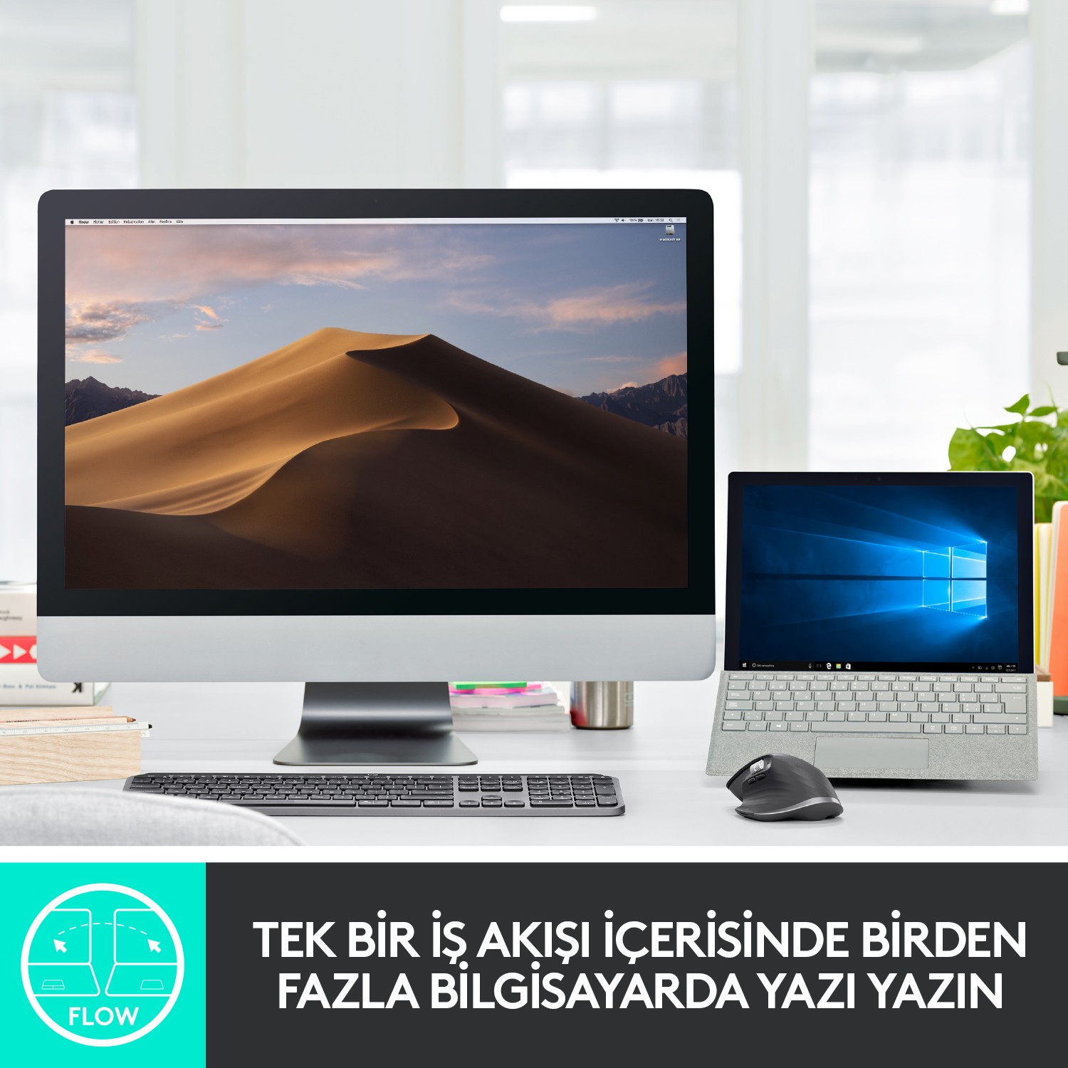 Beyaz bir masada bir masaüstü bilgisayar ve bir dizüstü bilgisayar, masaüstü bir kumul manzarası gösteriyor.