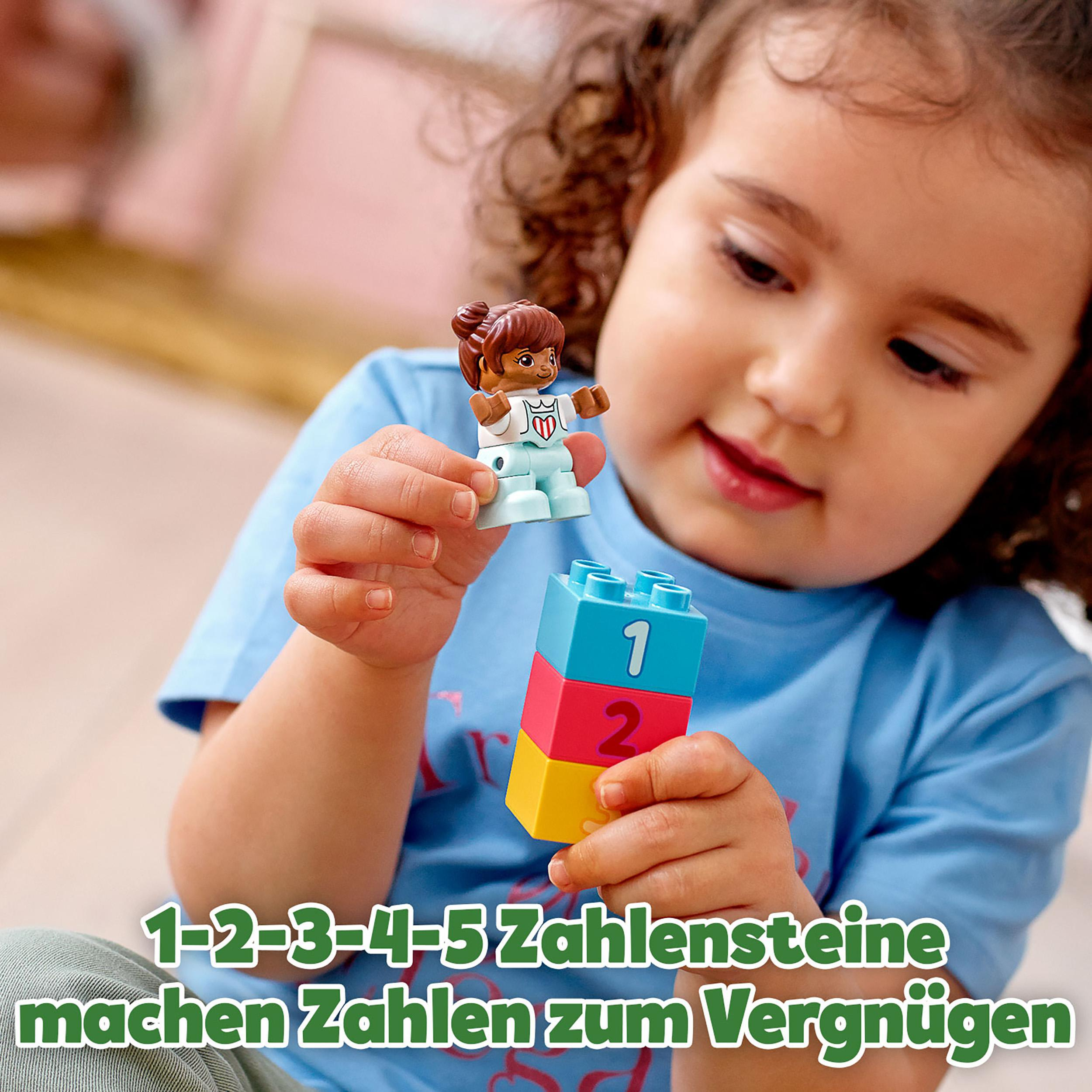 Ein junges Mädchen spielt mit bunten Blöcken und einer kleinen Figur. Text unten. HP-Anzeige.
