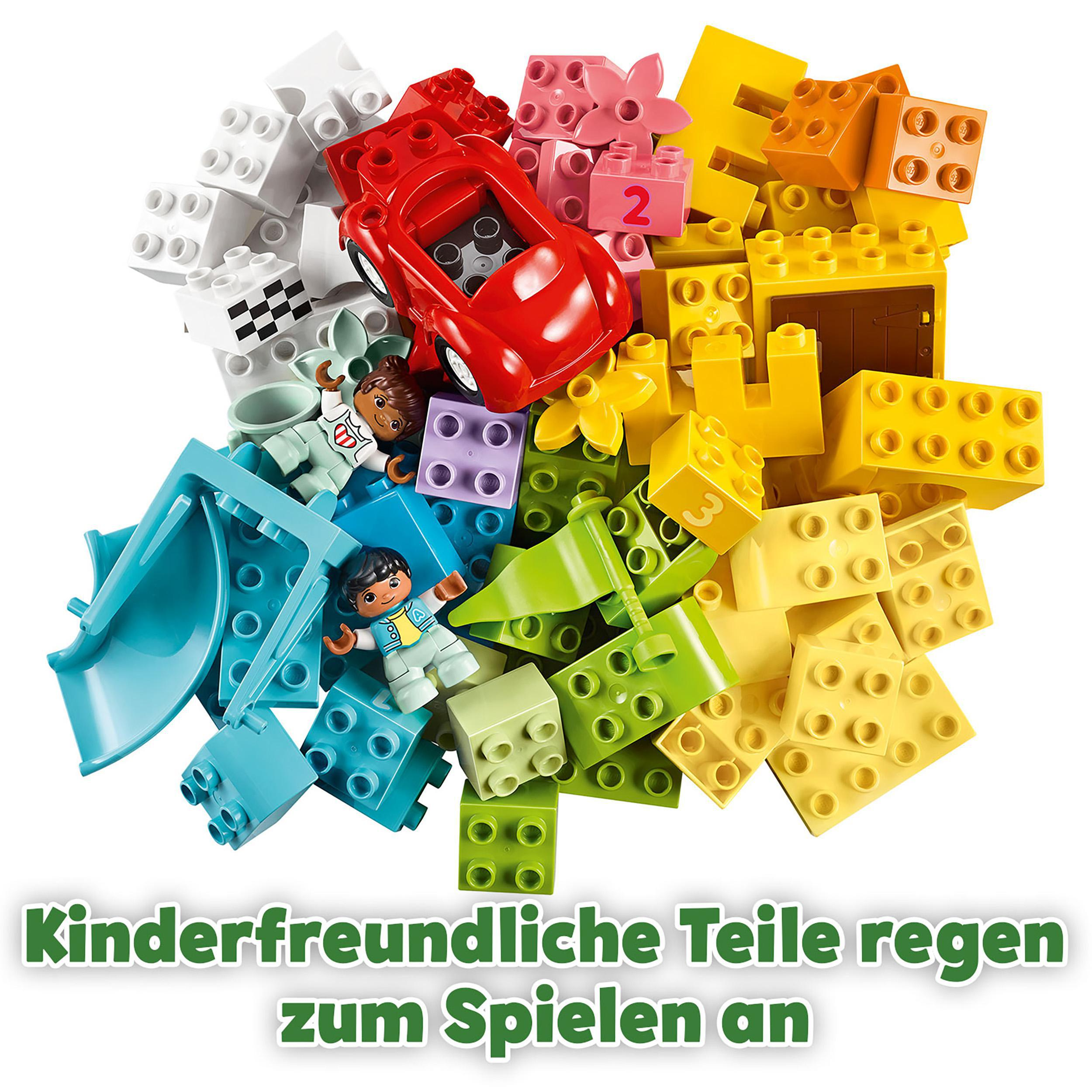 Lego Duplo Set mit verschiedenen bunten Blöcken, einem roten Auto und zwei Lego-Figuren. Text auf Deutsch.
