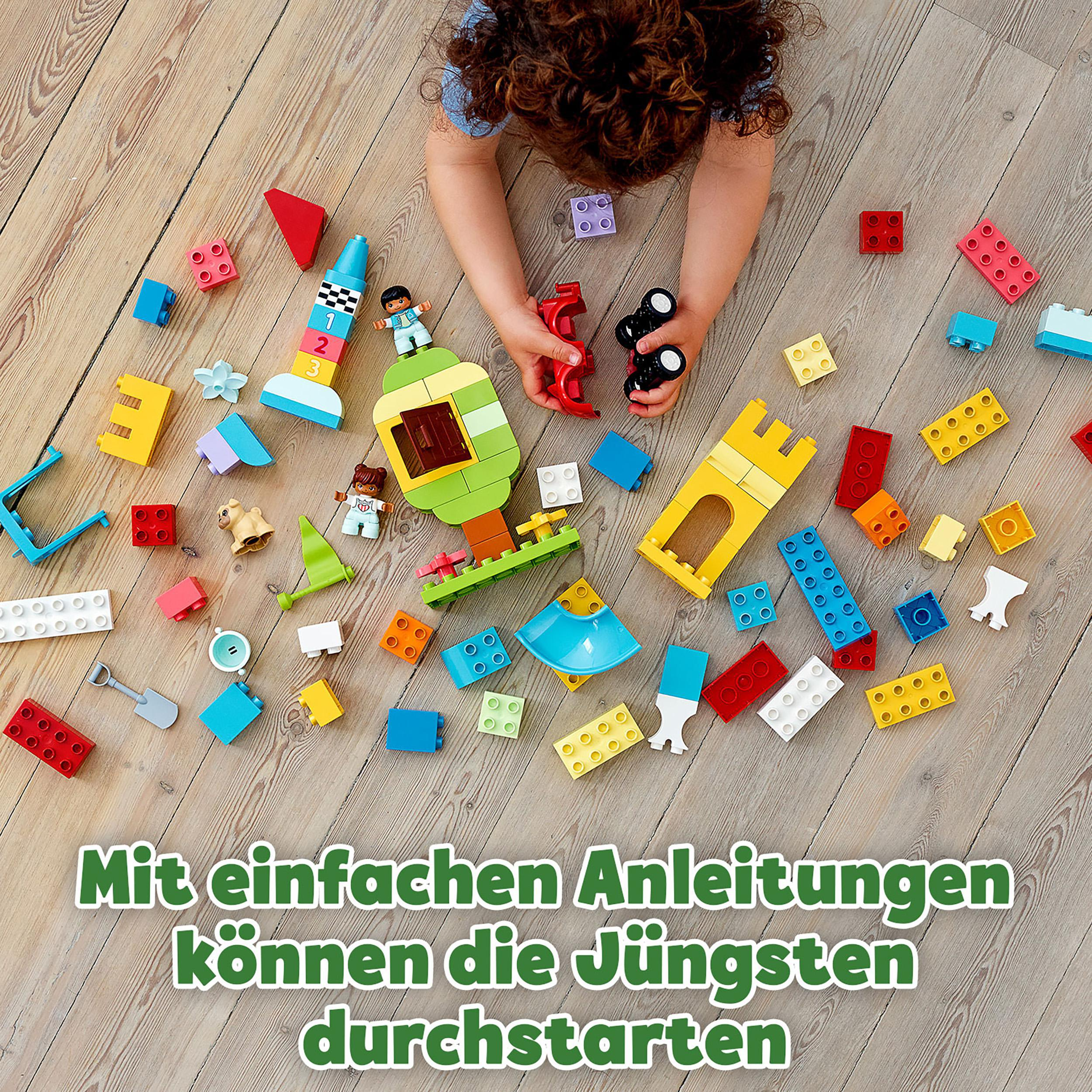 Ein Kind spielt mit bunten Bausteinen auf einem Holzboden, mit Text am unteren Rand.