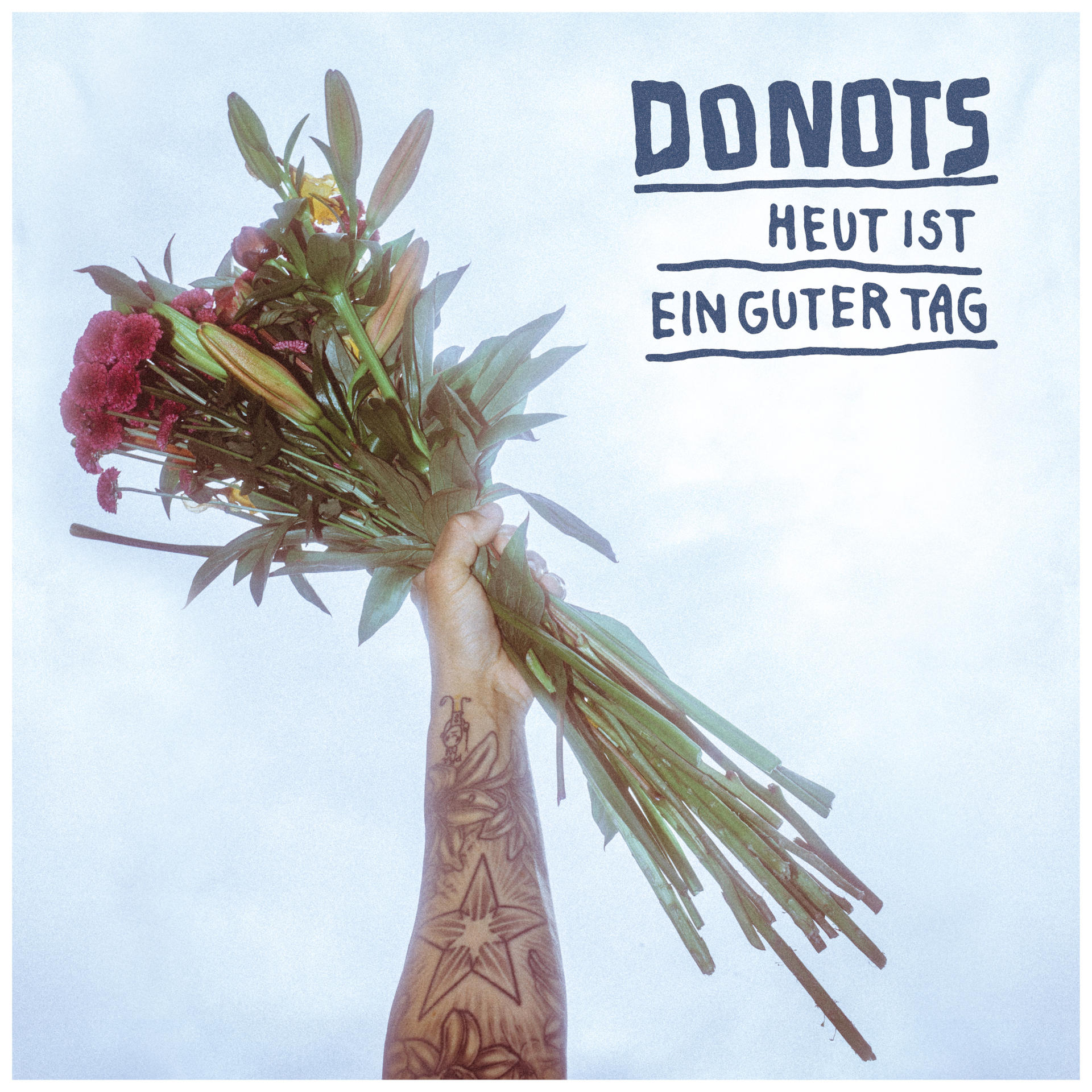 Eine Hand hält einen Blumenstrauß. Der Text 'DONOTS' und 'HEUT IST EIN GUTER TAG' sind im Bild.