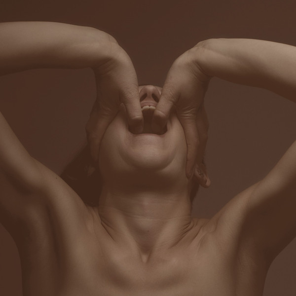 Une femme avec ses mains couvrant sa bouche, les yeux fermés, dans des tons sépia.