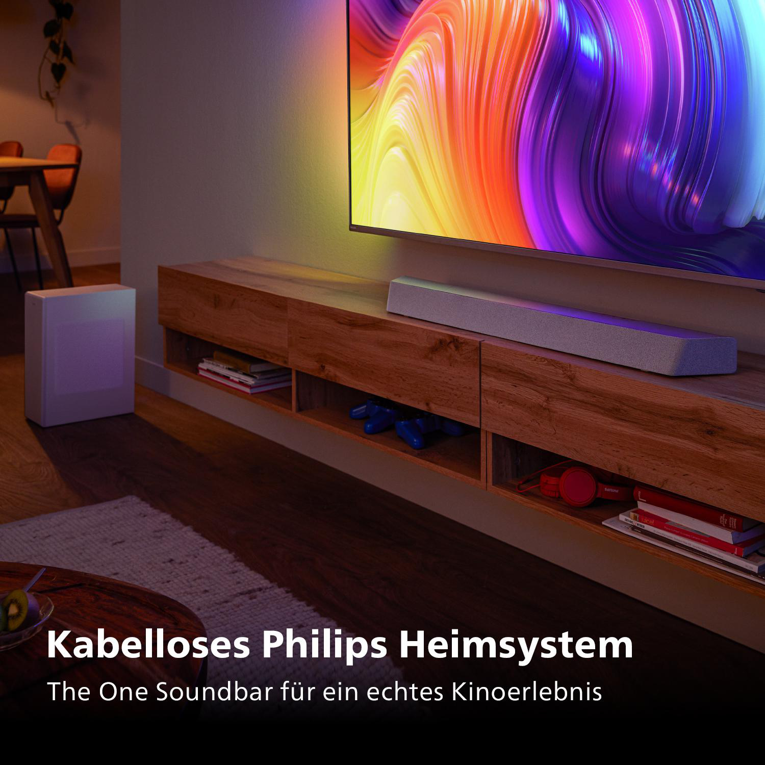 Wohnzimmer mit Fernseher, Soundbar und Schrank. Text: Kabelloses Philips Heimsystem.