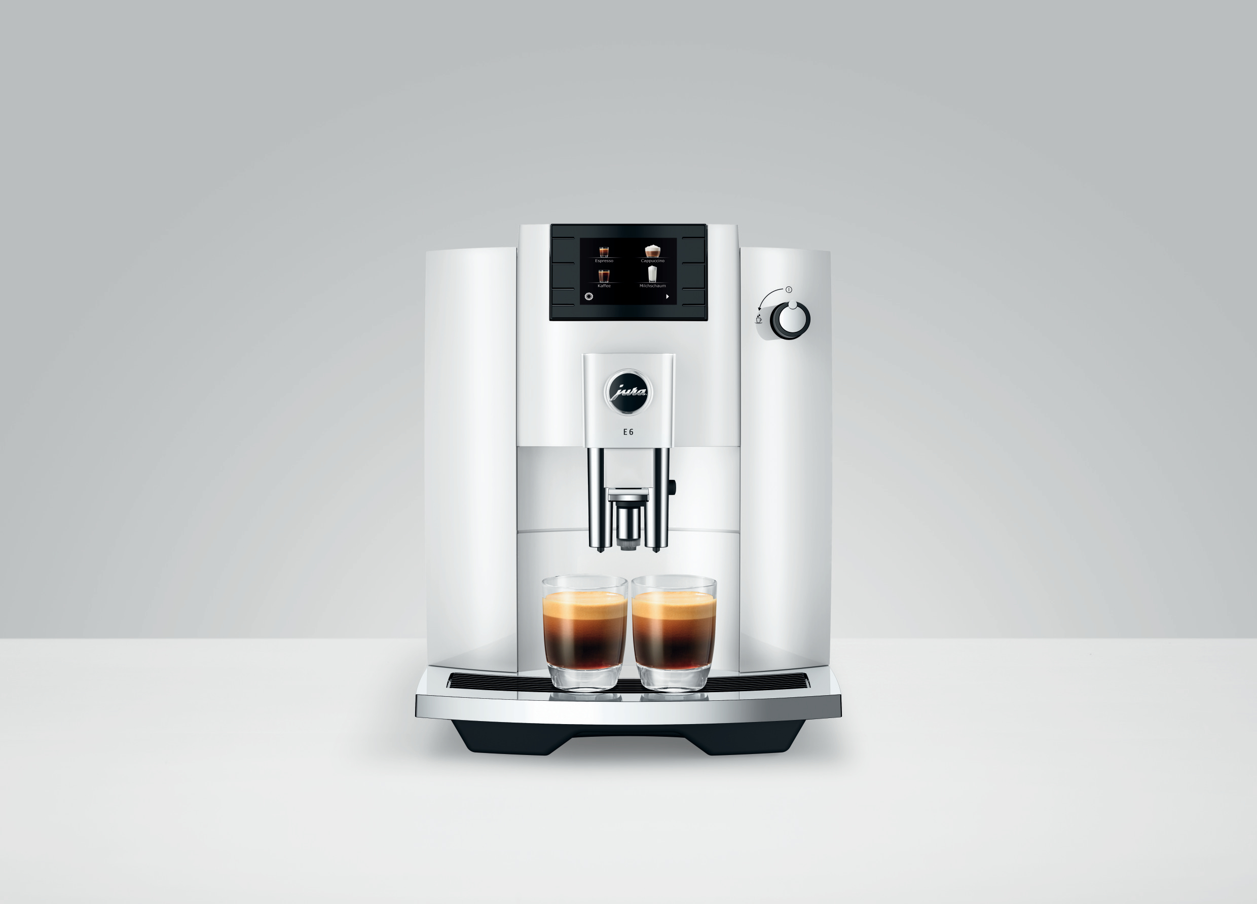 Eine weiße Kaffeemaschine mit zwei Kaffeegläsern auf dem Tisch.