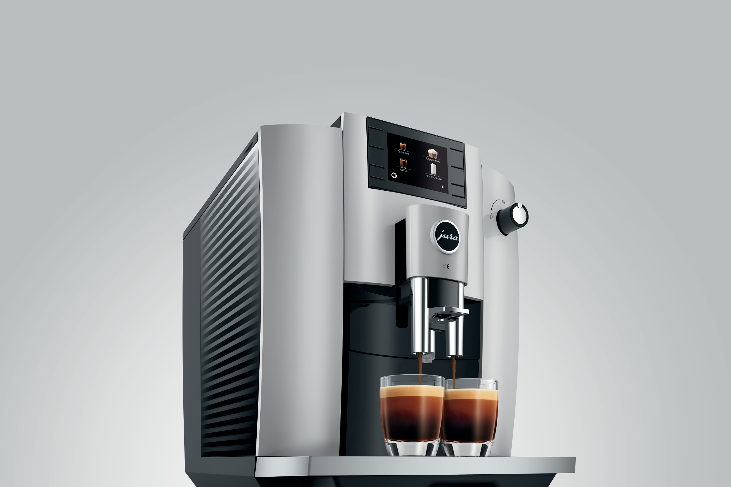 Eine silberne und schwarze Kaffeemaschine mit zwei Gläsern, die mit Espresso gefüllt werden.