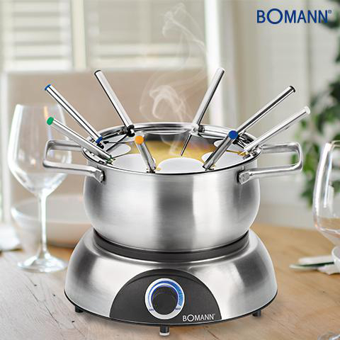 Ein Fondue-Set steht auf einem Tisch. Der Topf enthält Käse mit Gabeln. Im Hintergrund sind Weingläser zu sehen.