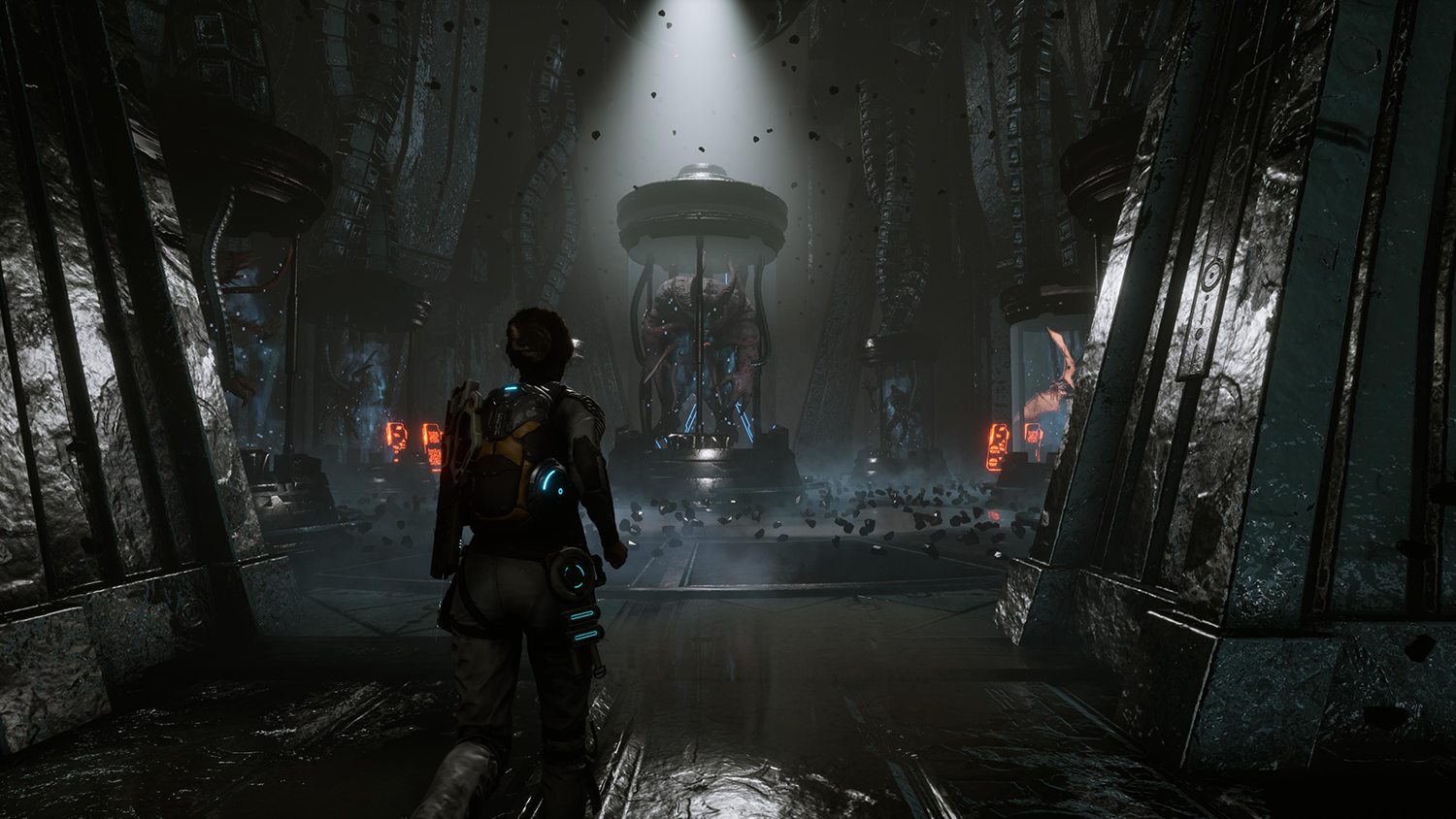 Donkere, futuristische game scene. Persoon in pak loopt naar oplichtend object in het midden.