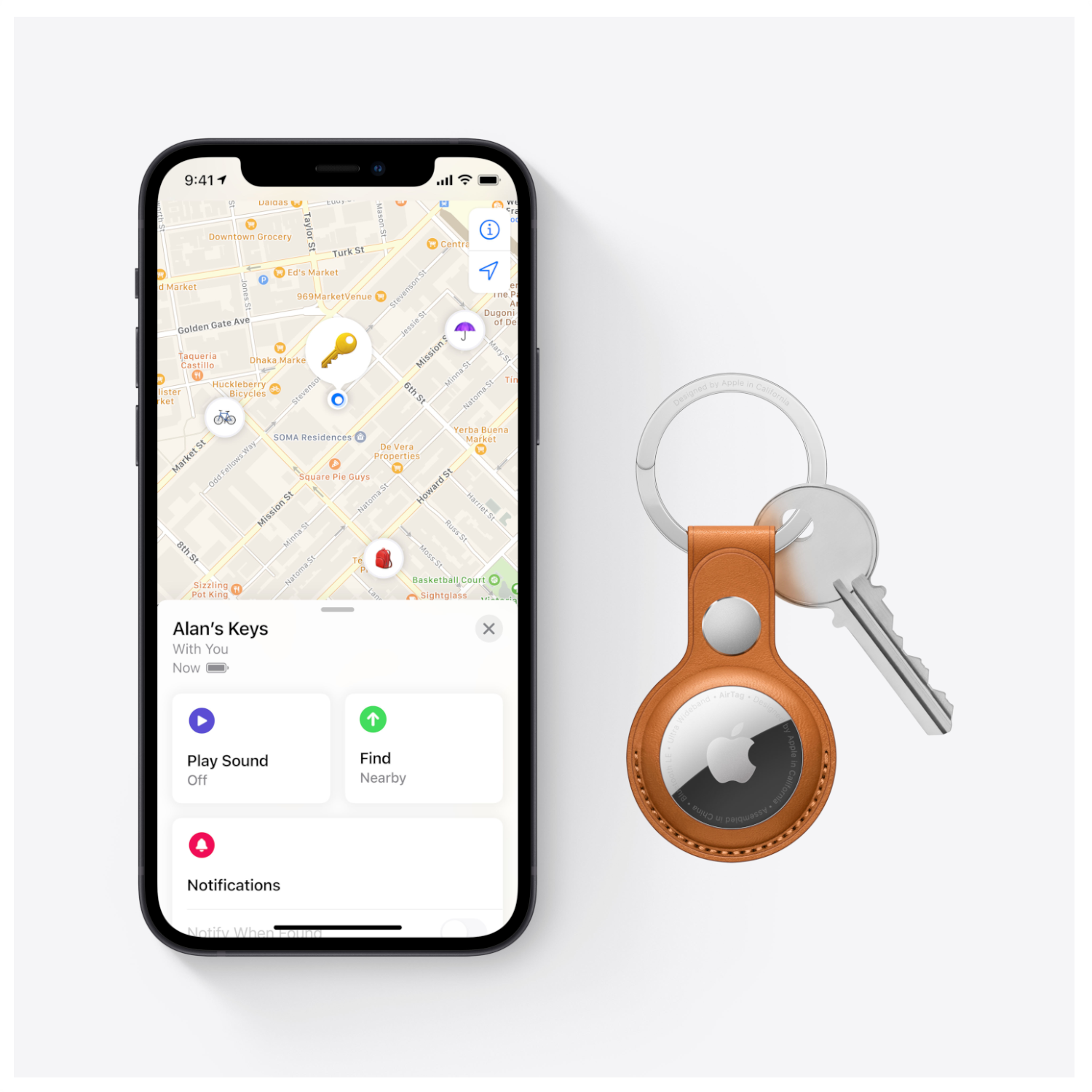 Een iPhone met een kaart die een locatie toont, een sleutelhanger en een sleutel.
