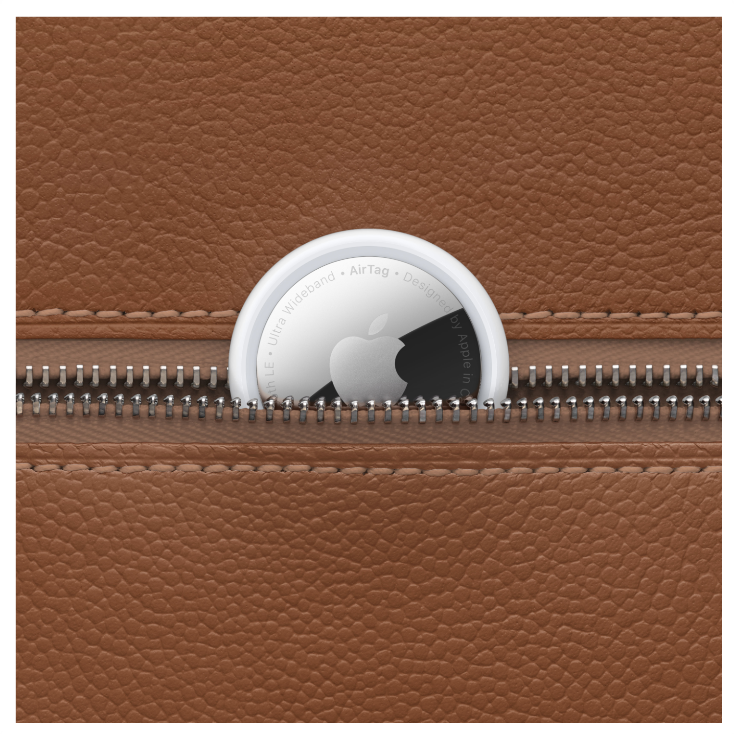 A brown leather material with a silver zipper. An Apple AirTag is visible inside the zipper.
