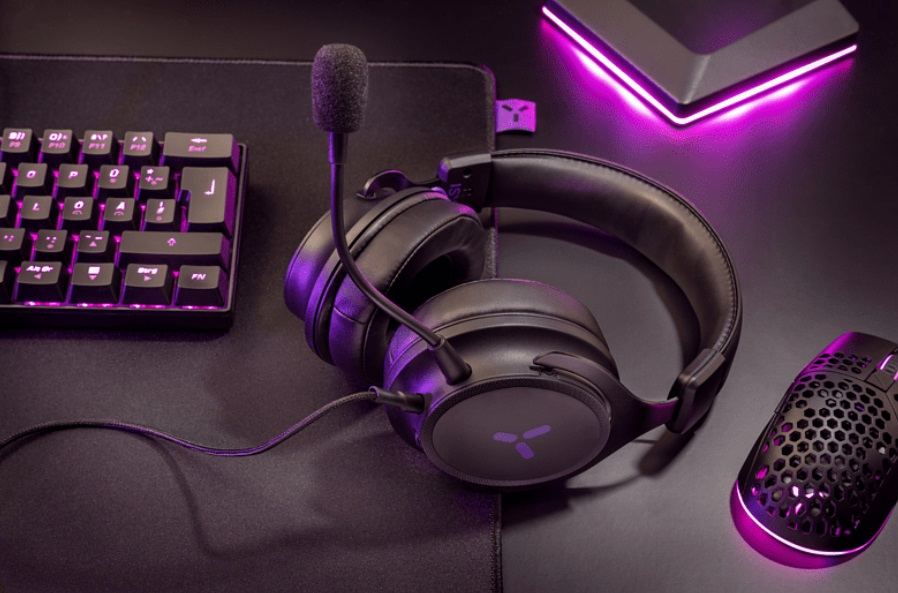 Una configuración de juego con auriculares, teclado, ratón y alfombrilla, todo en púrpura.