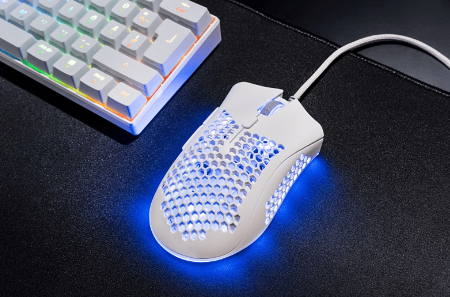 Ratón y teclado gaming blancos sobre alfombrilla negra. El teclado se ilumina.