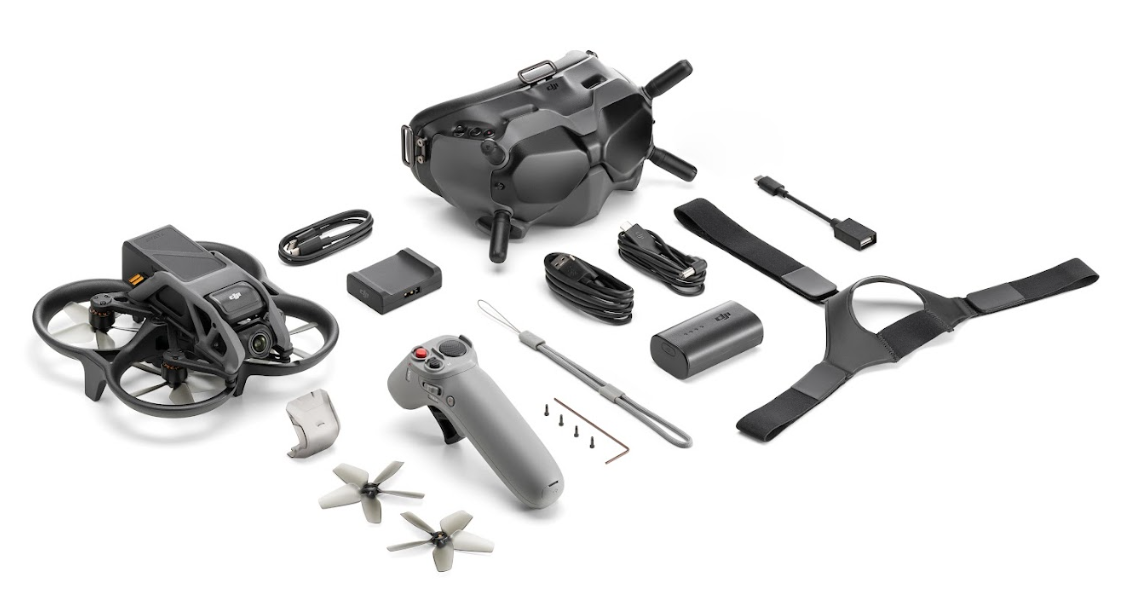 Een dronekit met drone, bril, controller, batterijen, kabels en accessoires, alles op een witte achtergrond.