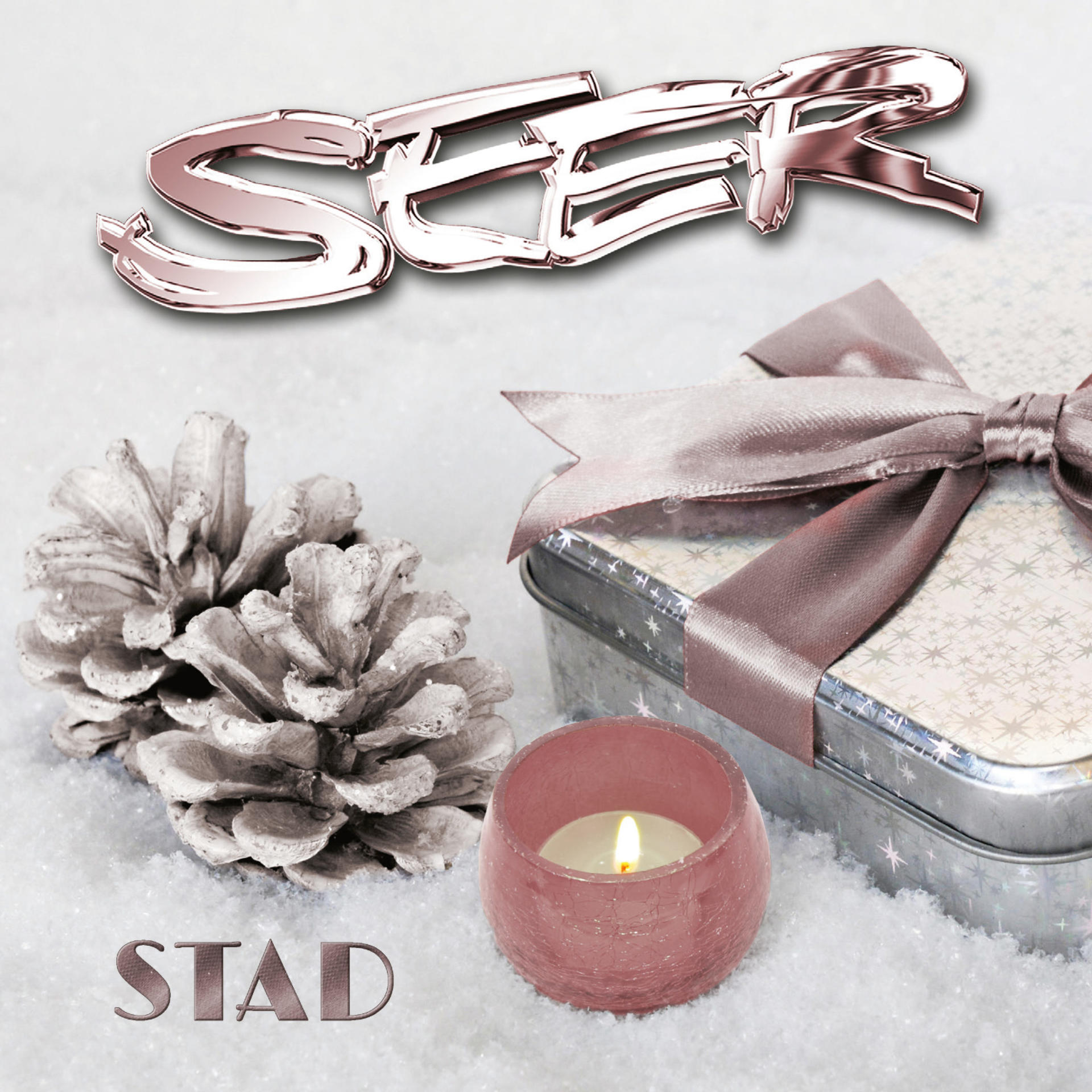 Weihnachtsszene mit Geschenkbox, Kerze, Tannenzapfen und dem Wort 'STAD', alles auf Schnee.