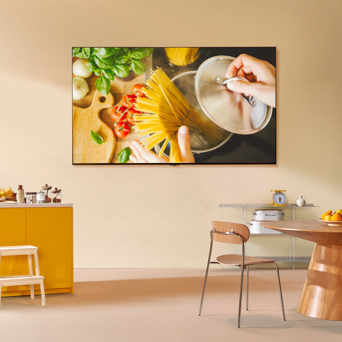 Escena de cocina con un televisor en la pared mostrando una escena de cocina.