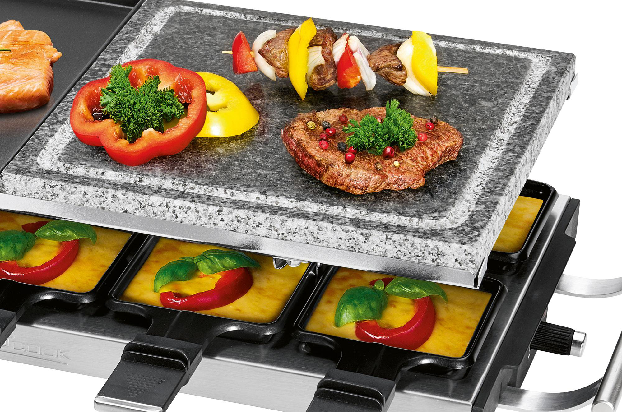 Ein Raclette-Grill mit gekochtem Essen darauf. Enthält gekochtes Fleisch, Gemüse und Käse.