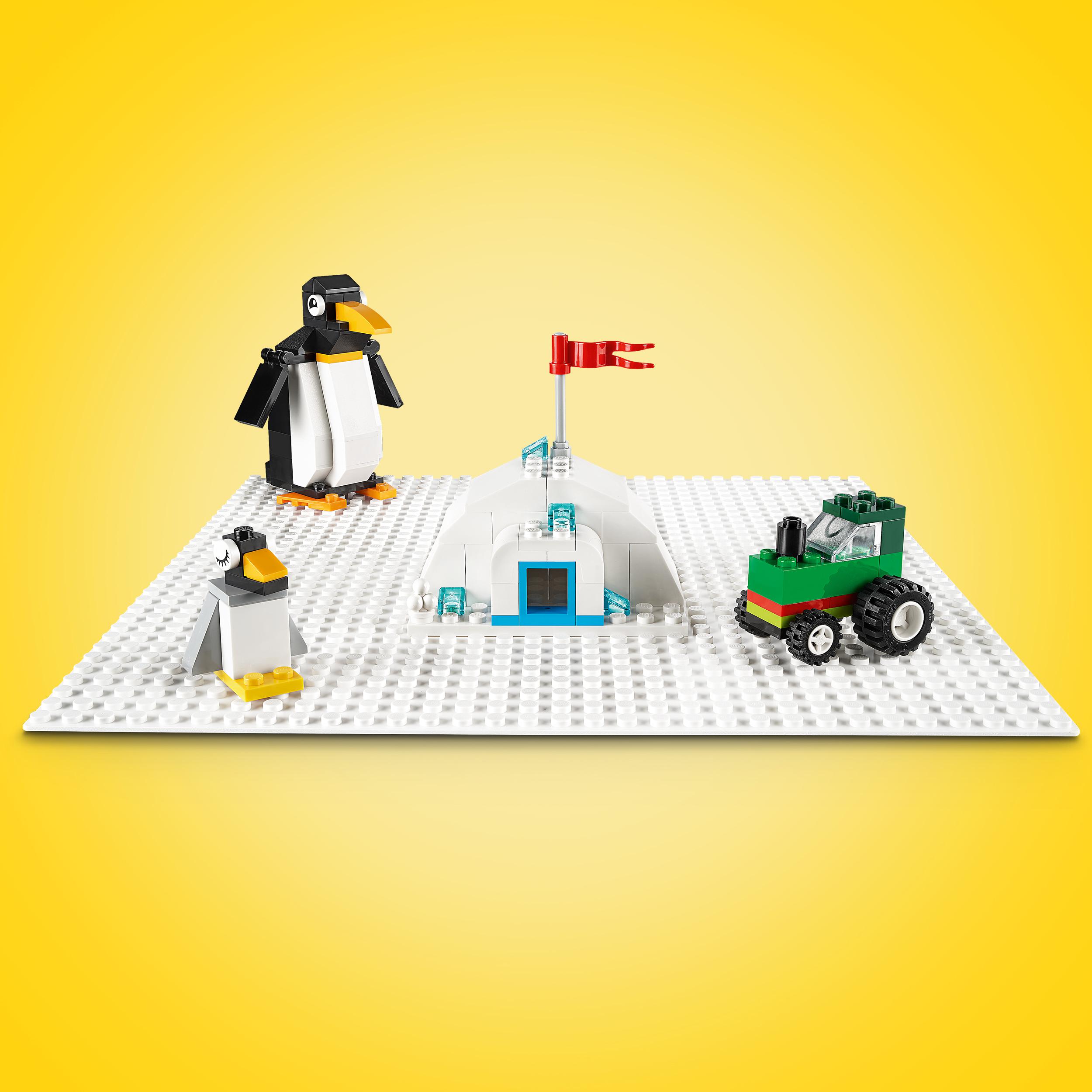 Lego-Set mit Pinguinen, Schnee und einem grünen Fahrzeug. Eine rote Flagge auf der Eisstruktur.