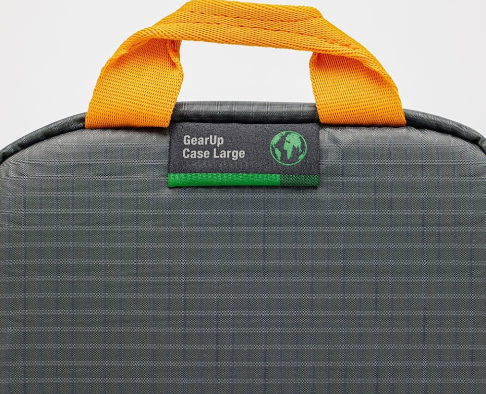 Custodia GearUp grigia e nera con manico arancione. Un'etichetta verde e grigia sul davanti.