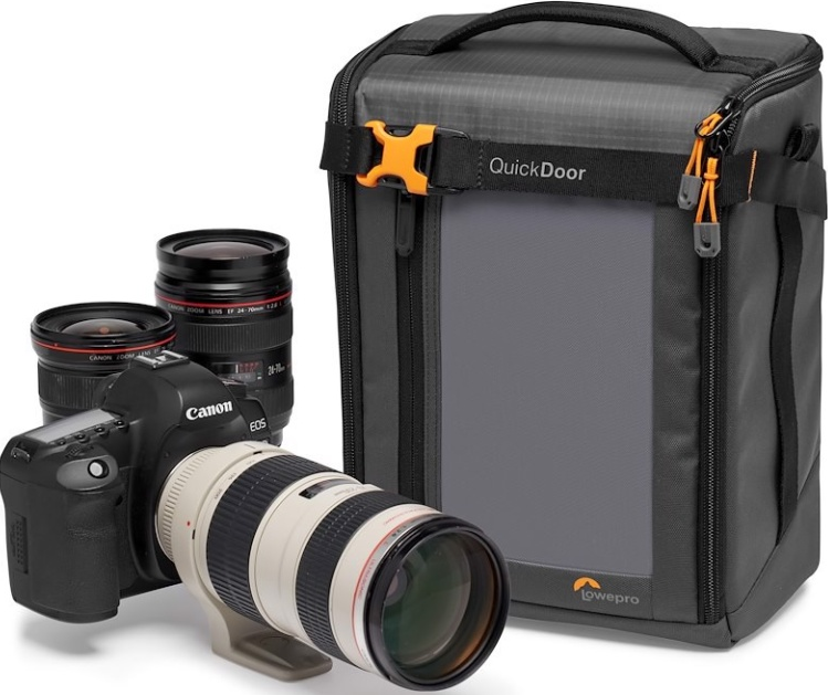 Un appareil photo Canon avec des objectifs et un sac photo LowePro. Le sac est noir et gris. Les objectifs sont noirs et blancs.