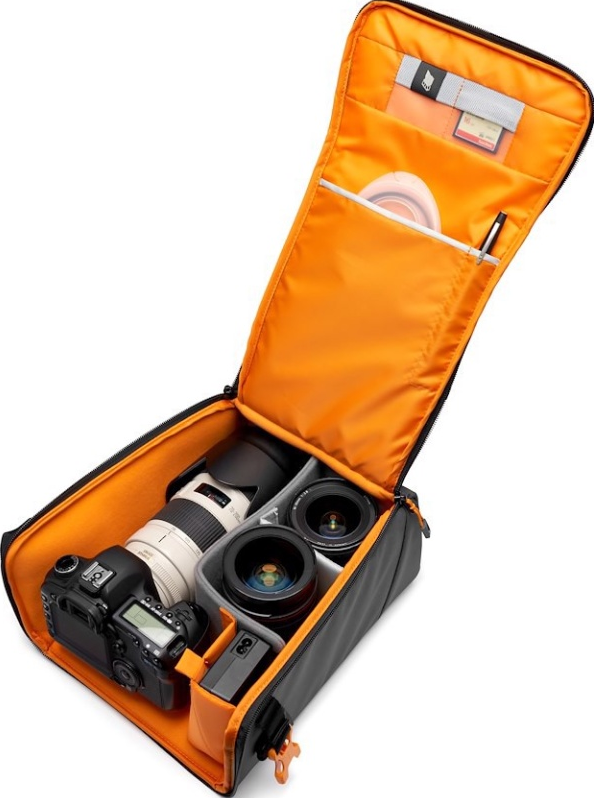 Sac photo ouvert avec appareil photo, objectifs et accessoires. Intérieur orange, extérieur noir. Contient appareil photo, objectif et cartes mémoire.