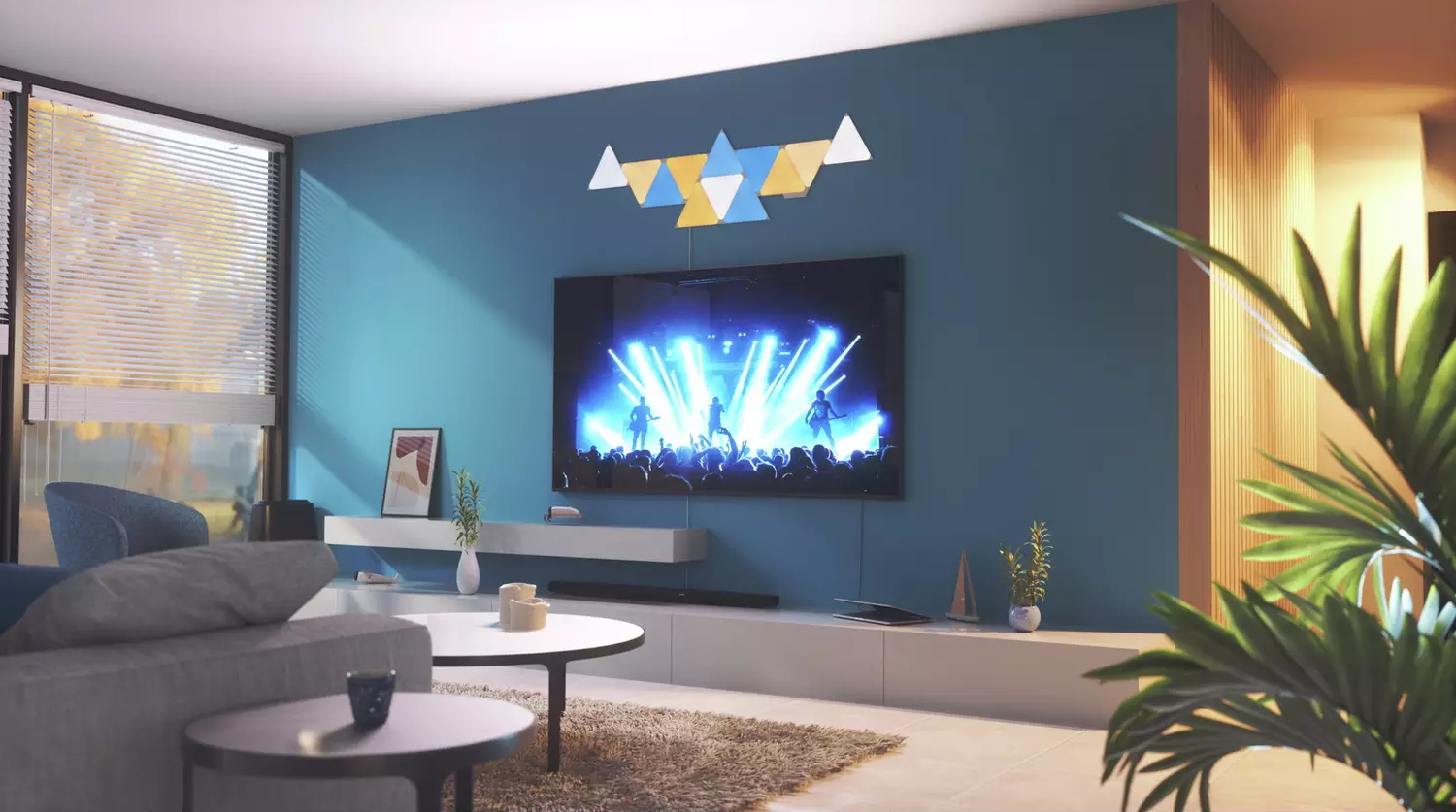 Un soggiorno moderno con una parete blu, TV e arte murale. Ci sono piante e mobili.