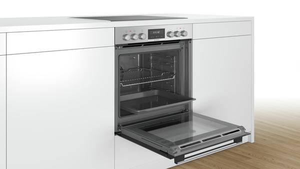 Ein eingebauter Backofen mit geöffneter Tür, der Gestelle und ein Tablett zeigt.