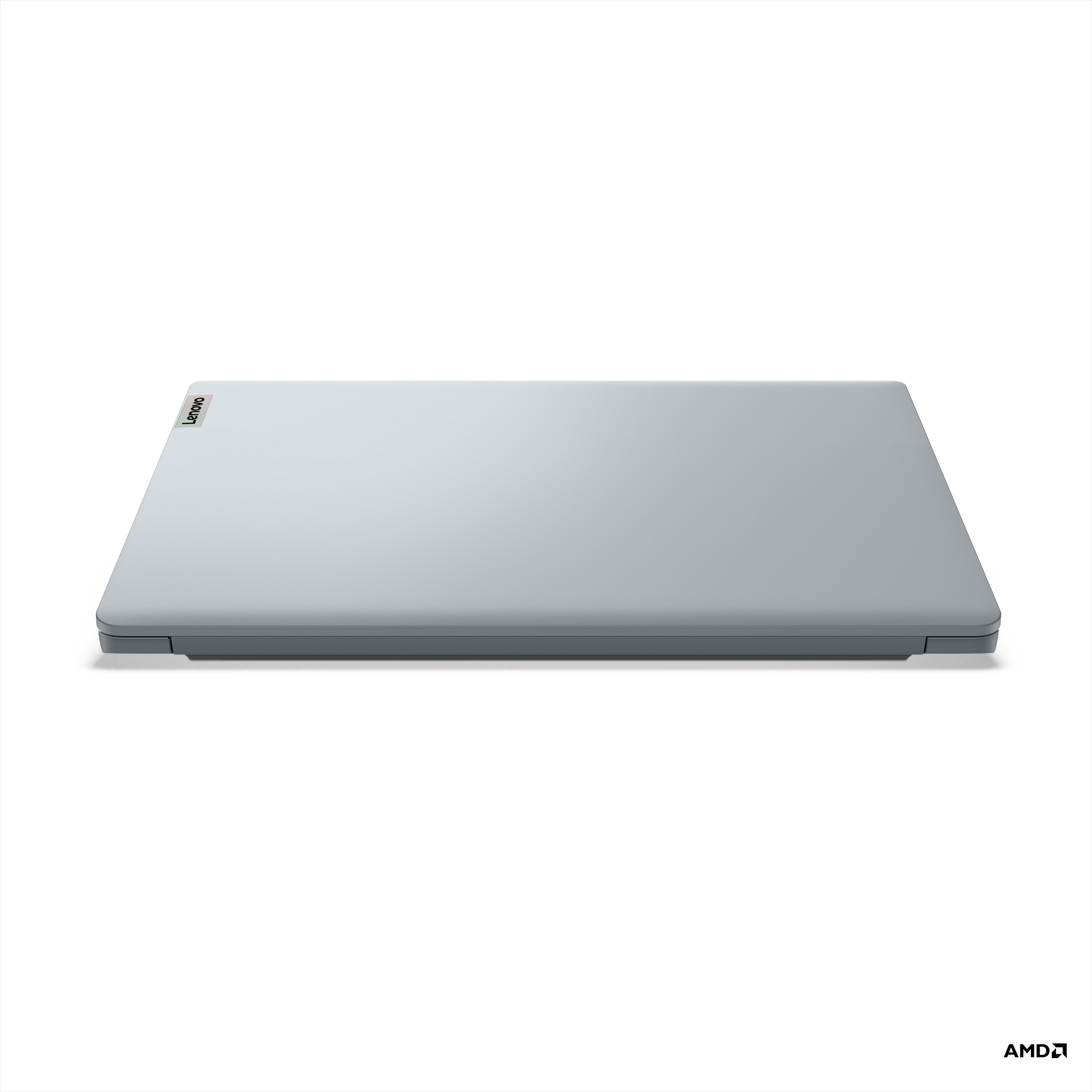 Beyaz bir yüzeyde kapalı gri Lenovo dizüstü bilgisayar, Lenovo logosu görünür. Alt kısımda AMD logosu.
