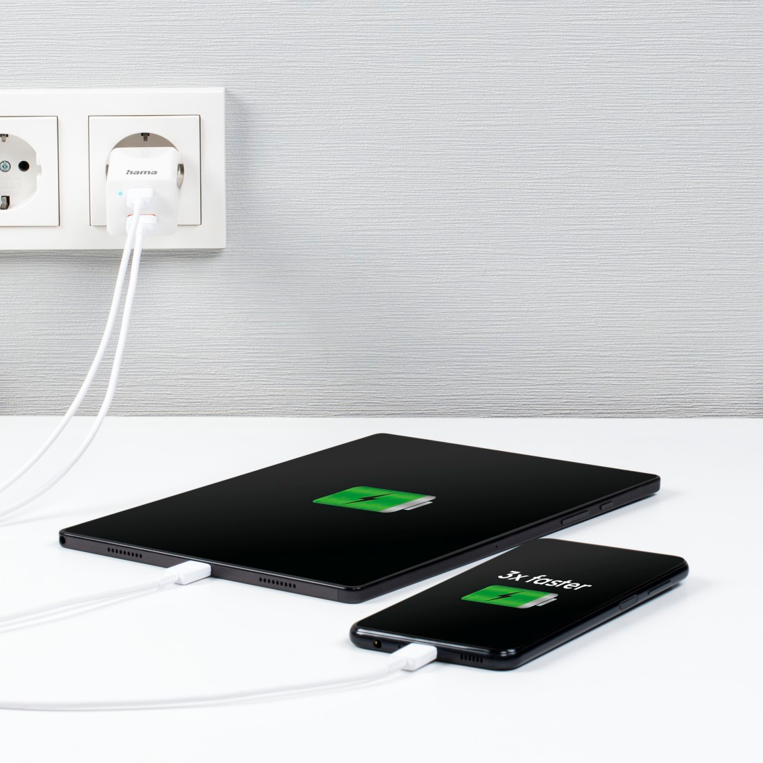 A tablet and phone charging side-by-side from a white wall outlet, stating '3x faster'.