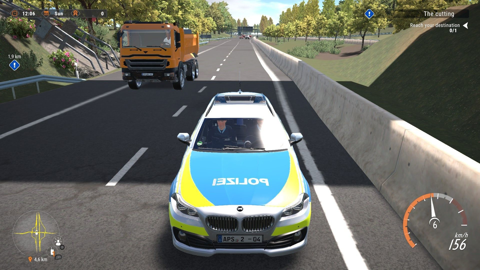 Ein Polizeiauto fährt auf einer Autobahn, mit einem LKW davor.