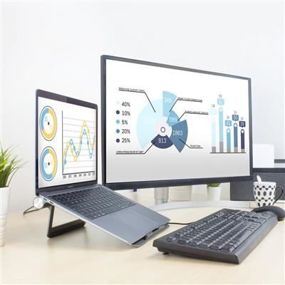 Laptop on a stand with a monitor and keyboard. Graphs and charts are visible on screens.