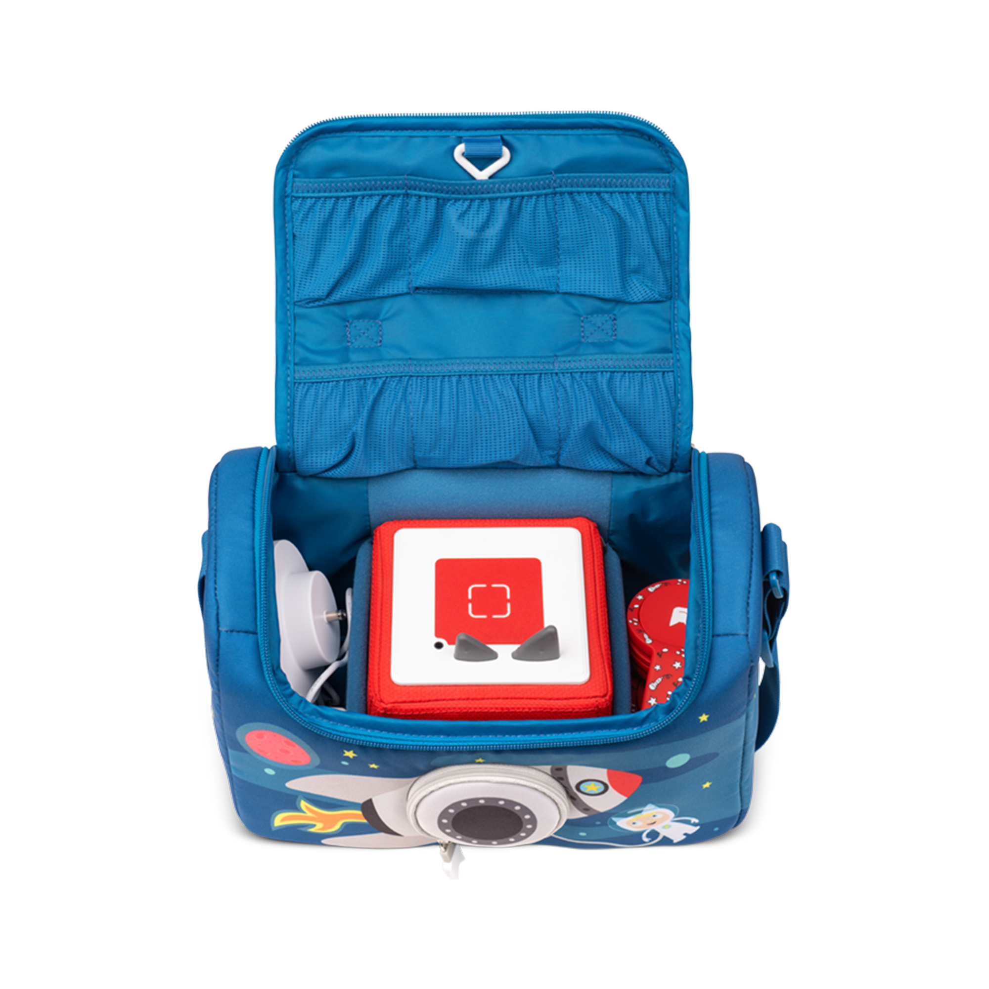 Eine blaue Tasche, offen, mit einem roten Würfel, einem weißen Ladegerät und anderen Gegenständen.