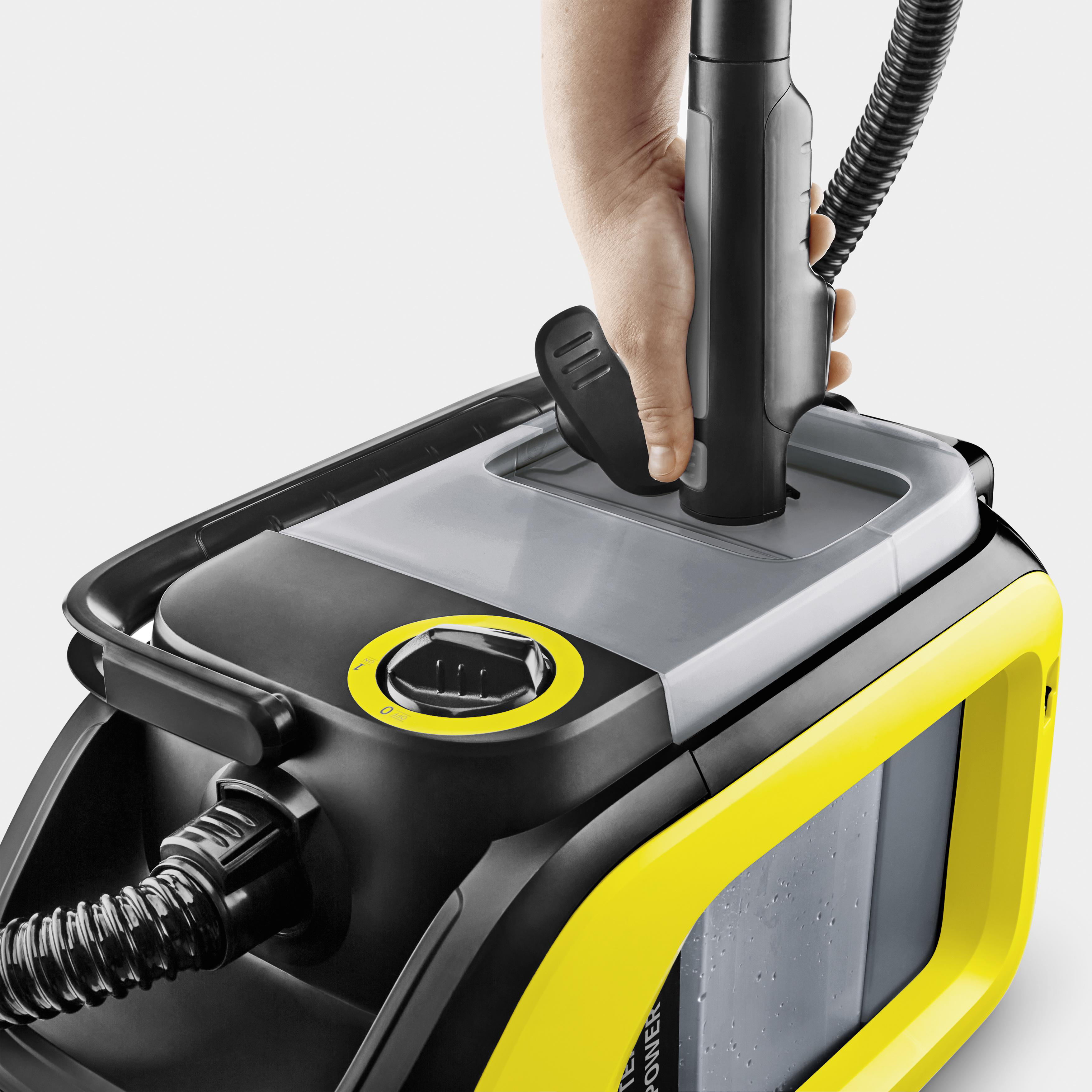 Hand, die einen Kärcher-Dampfreiniger benutzt, mit gelbem und schwarzem Design.