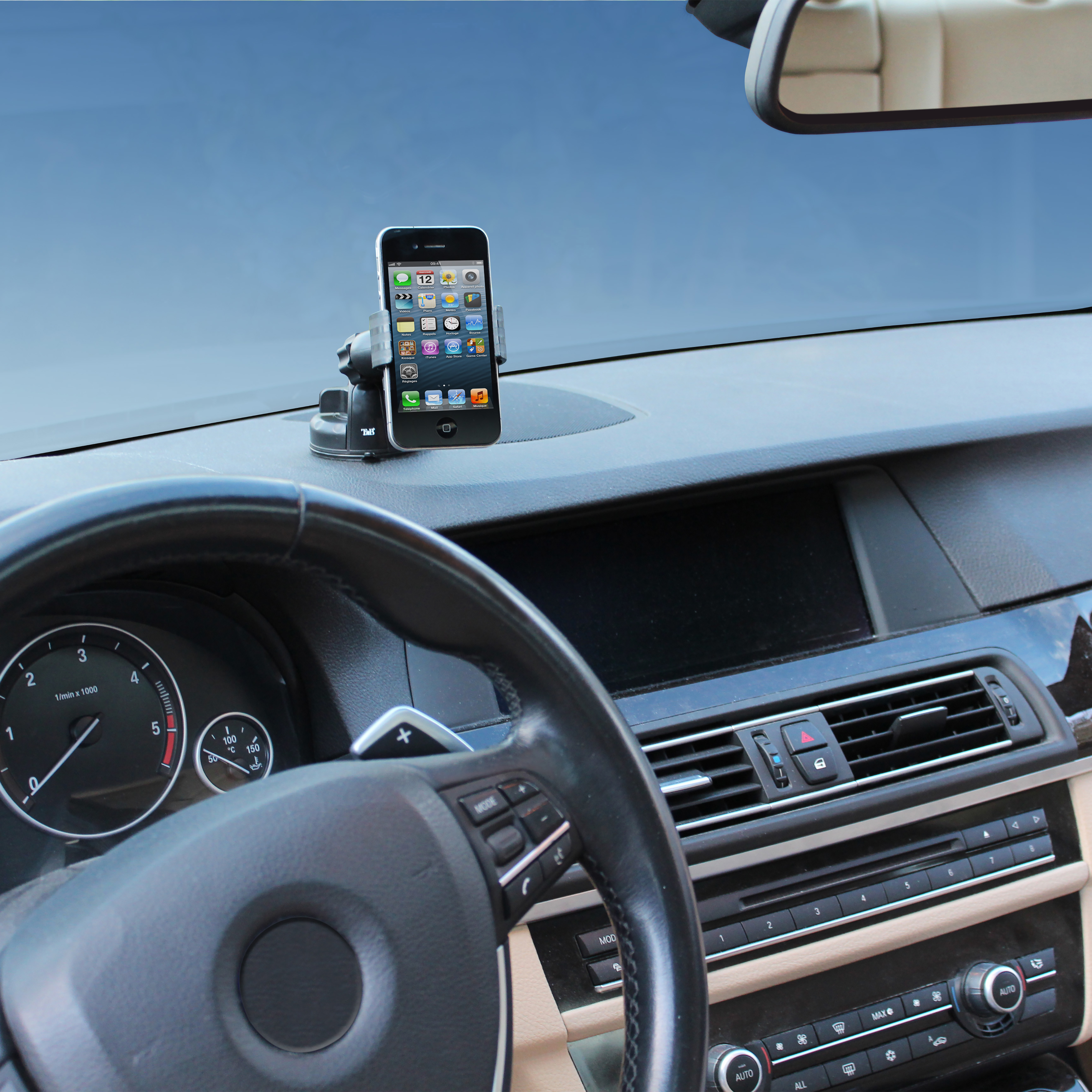 Un smartphone monté sur le tableau de bord d'une voiture. L'écran affiche des icônes d'applications.