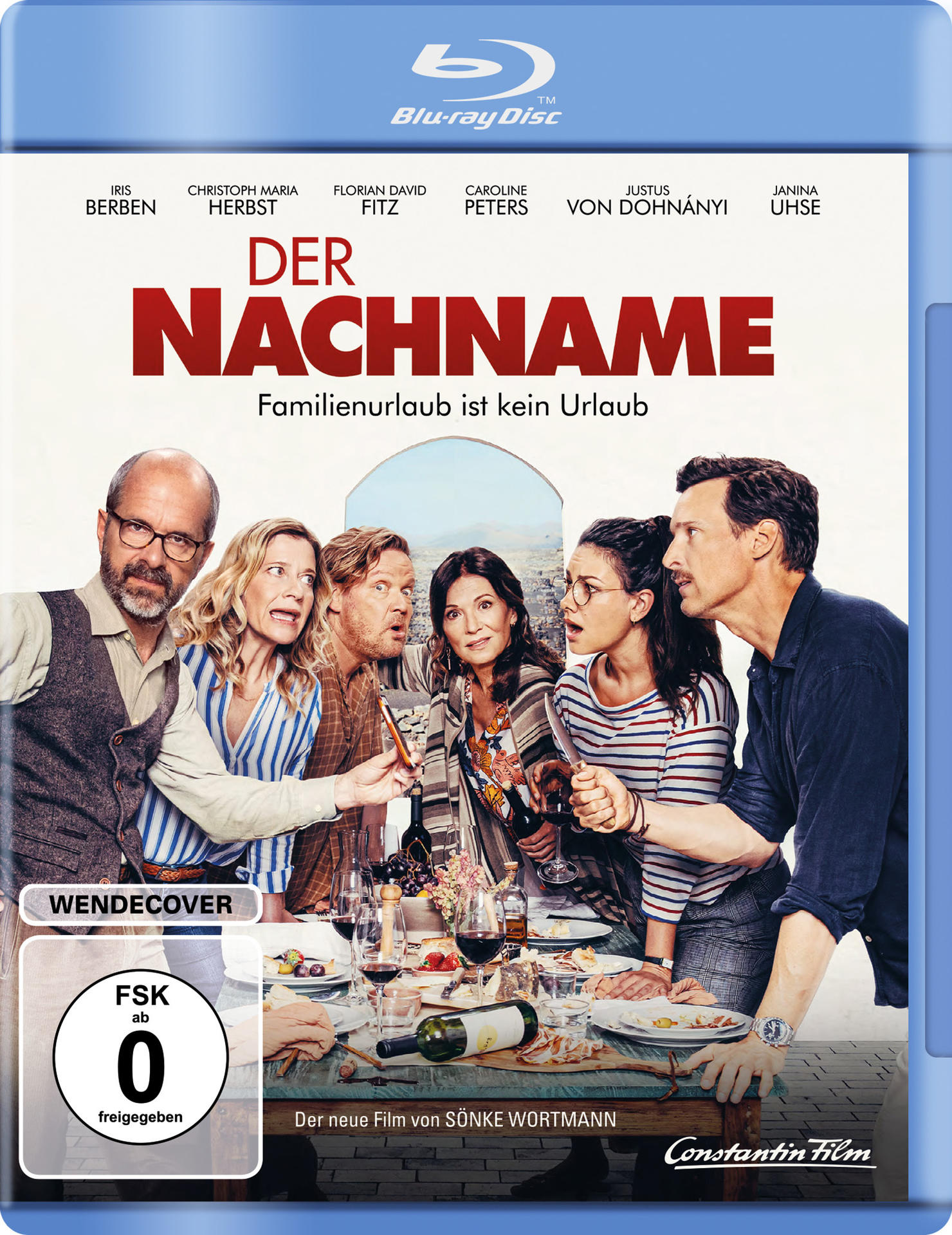 Filmcover. Gruppe von Leuten an einem Tisch, Text auf Deutsch: Der Nachname.
