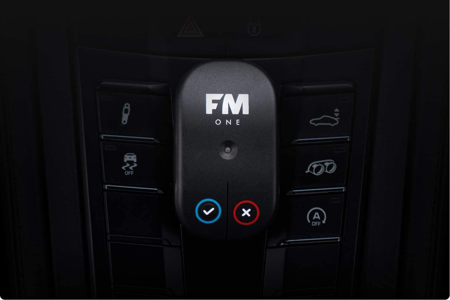 Een zwart FM ONE-apparaat op een autodashboard. Met vink- en kruisknop. Het interieur is zwart.