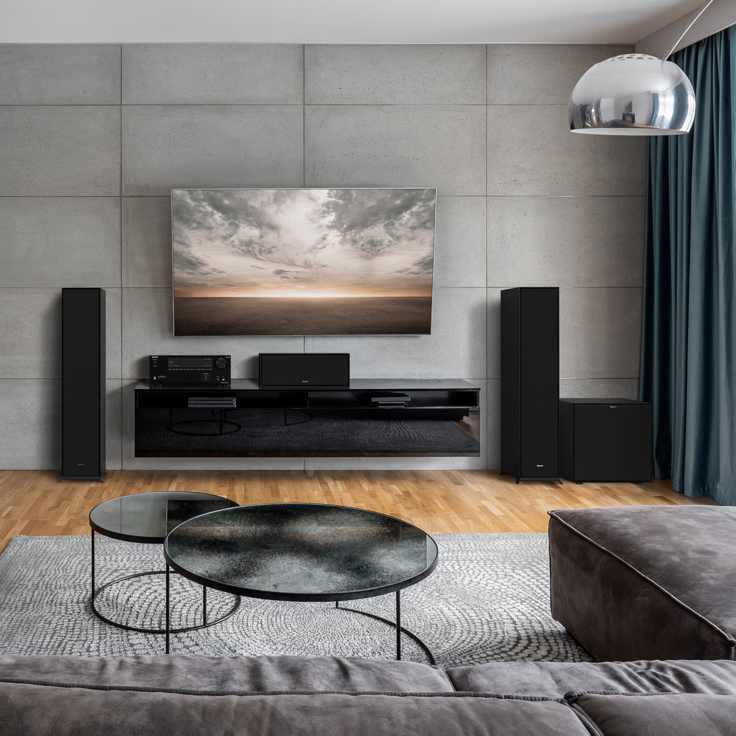 Un salon moderne avec une grande télévision, des enceintes et une table basse.
